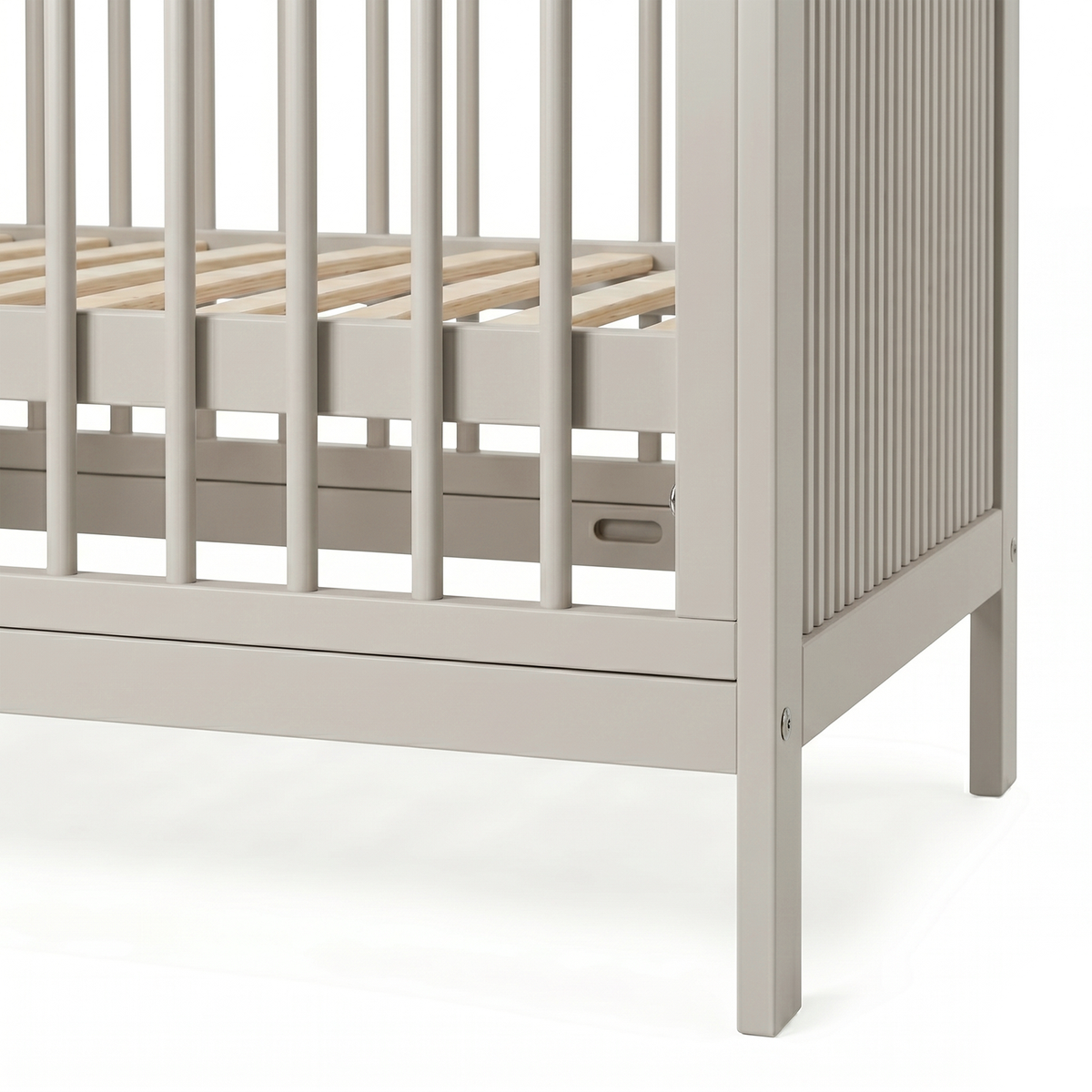 Close-up of lower corner and slats of crib on white background