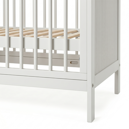 Close-up of white crib corner and slatted side on white background