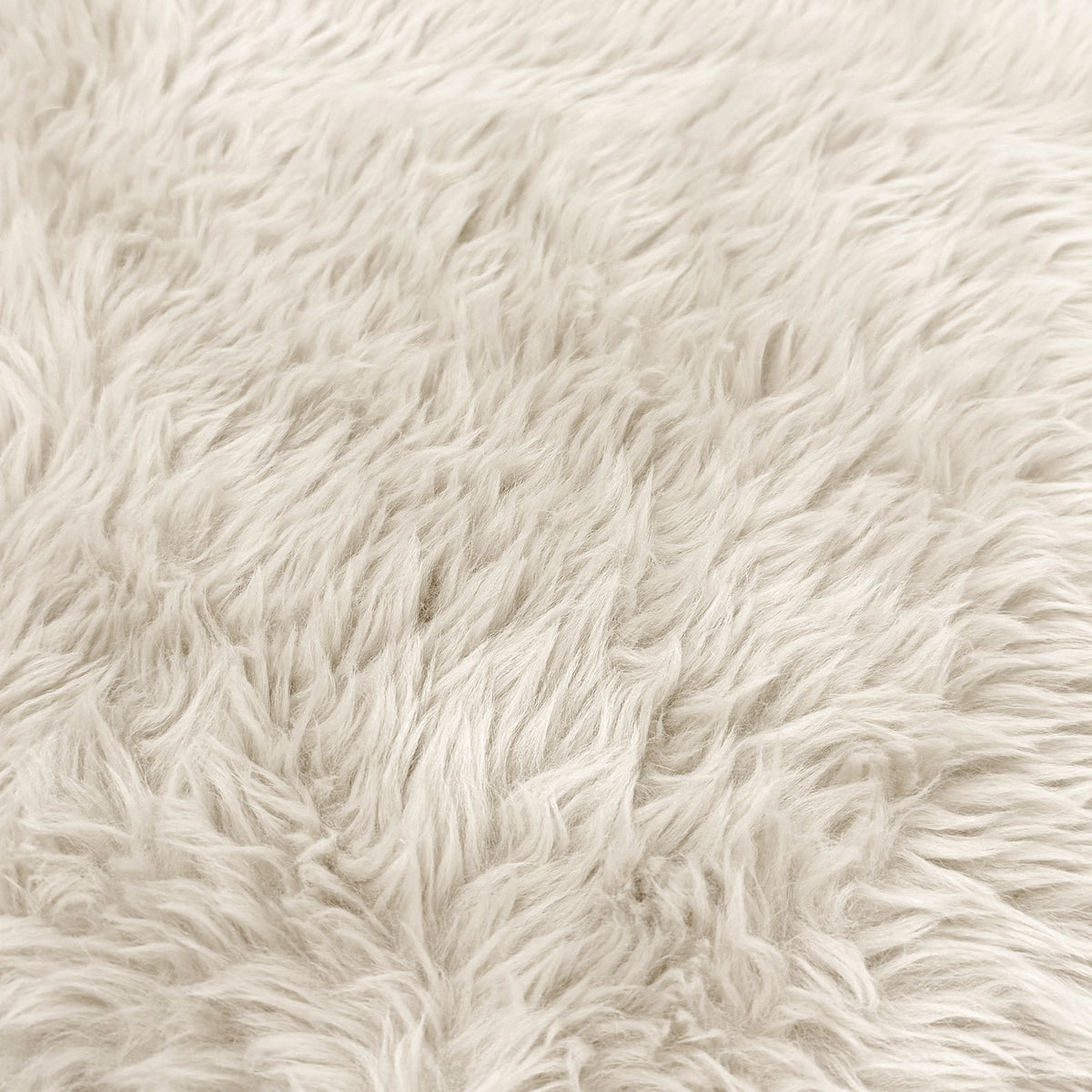 Close-up of cream faux fur upholstery texture.