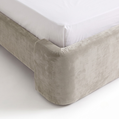 Close angled view of an upholstered bed frame corner on a white background