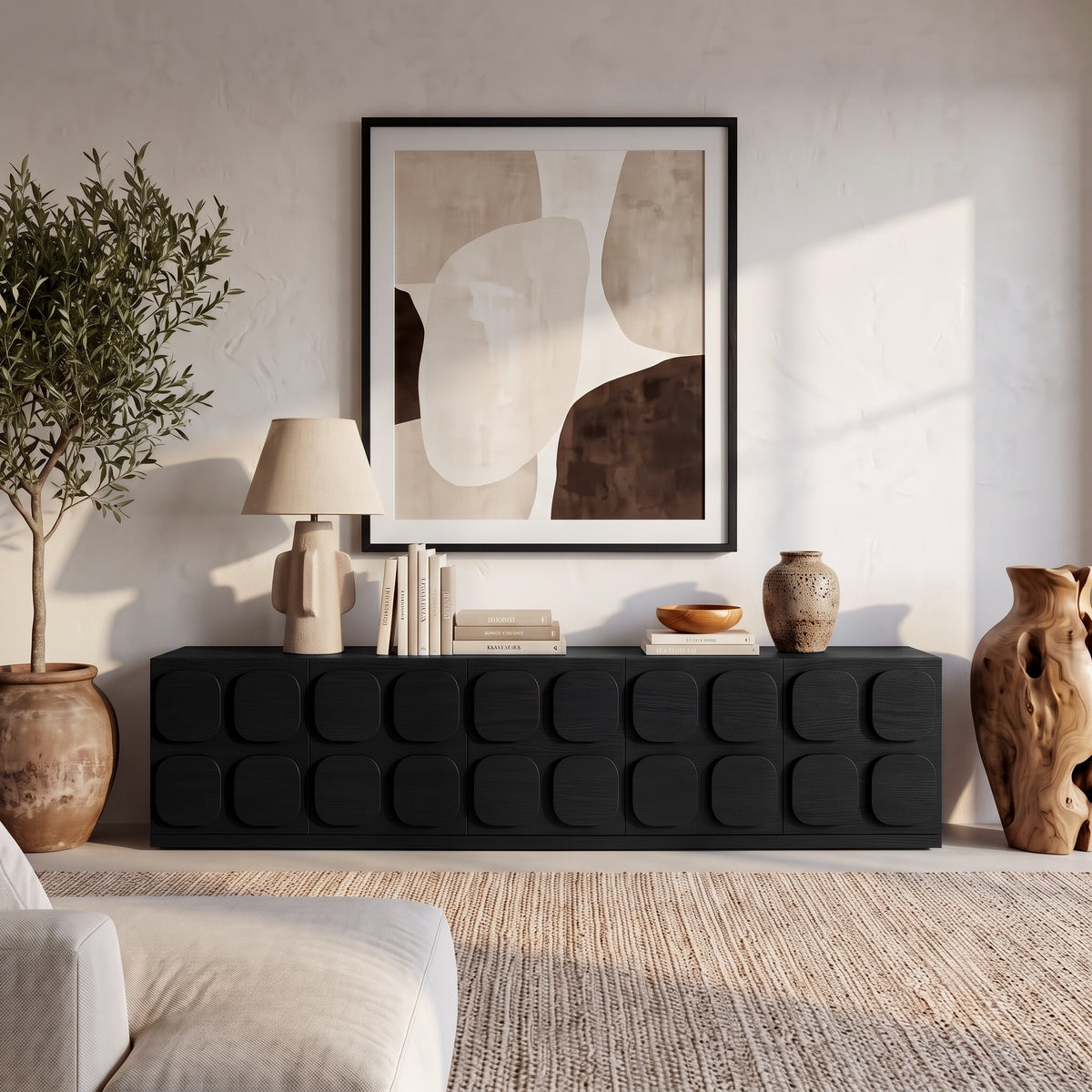 Black sideboard styled in a modern living room with decor and artwork