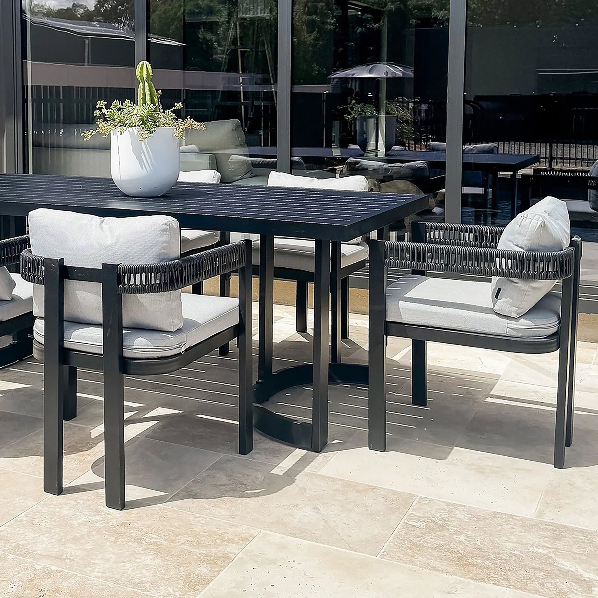 Modern outdoor dining set with table and four chairs on a patio