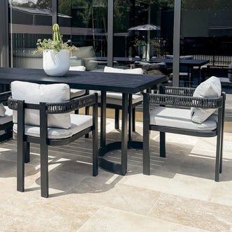 Modern outdoor dining set with table and four chairs on a patio
