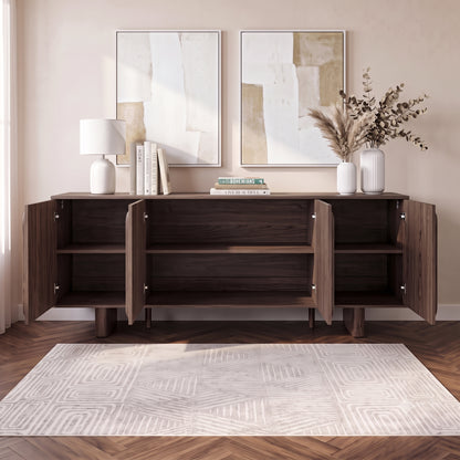 Dark wood sideboard in a styled room with lamp, books, artwork, and rug.