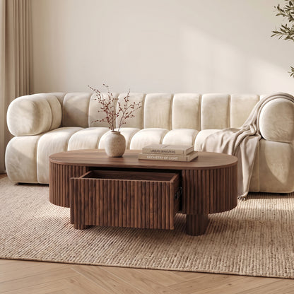 Wooden oval coffee table in a styled living room with sofa and decor