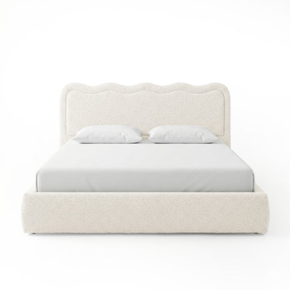 Front-facing upholstered bed with scalloped headboard on white background