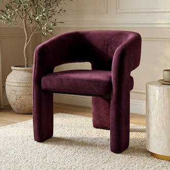 Plum velvet accent chair styled in a modern room