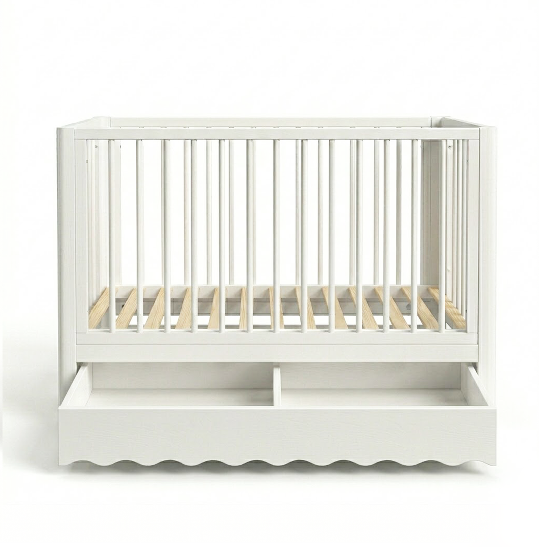 White baby crib on white background showing scalloped bottom edge and drawer