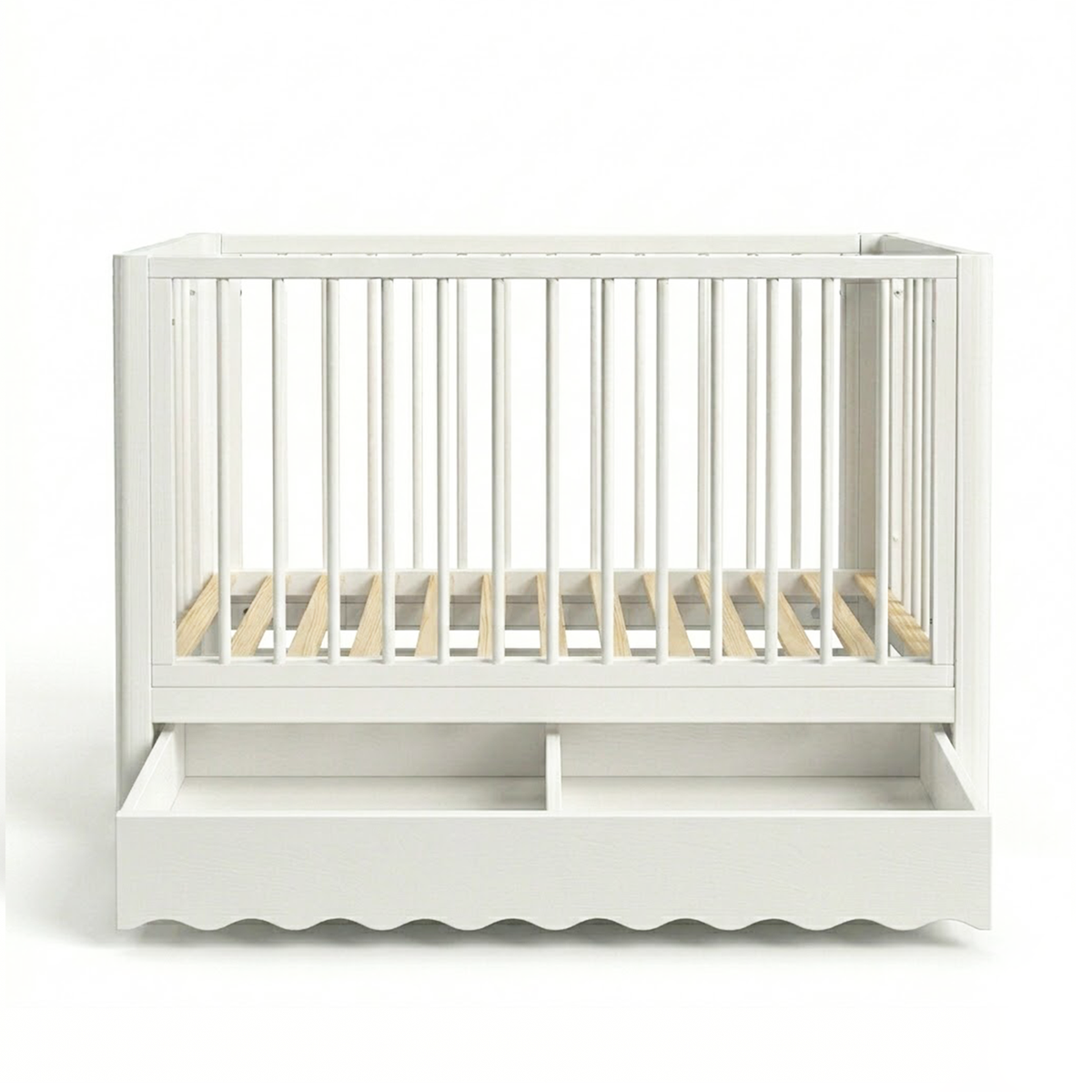 White baby crib on white background showing scalloped bottom edge and drawer
