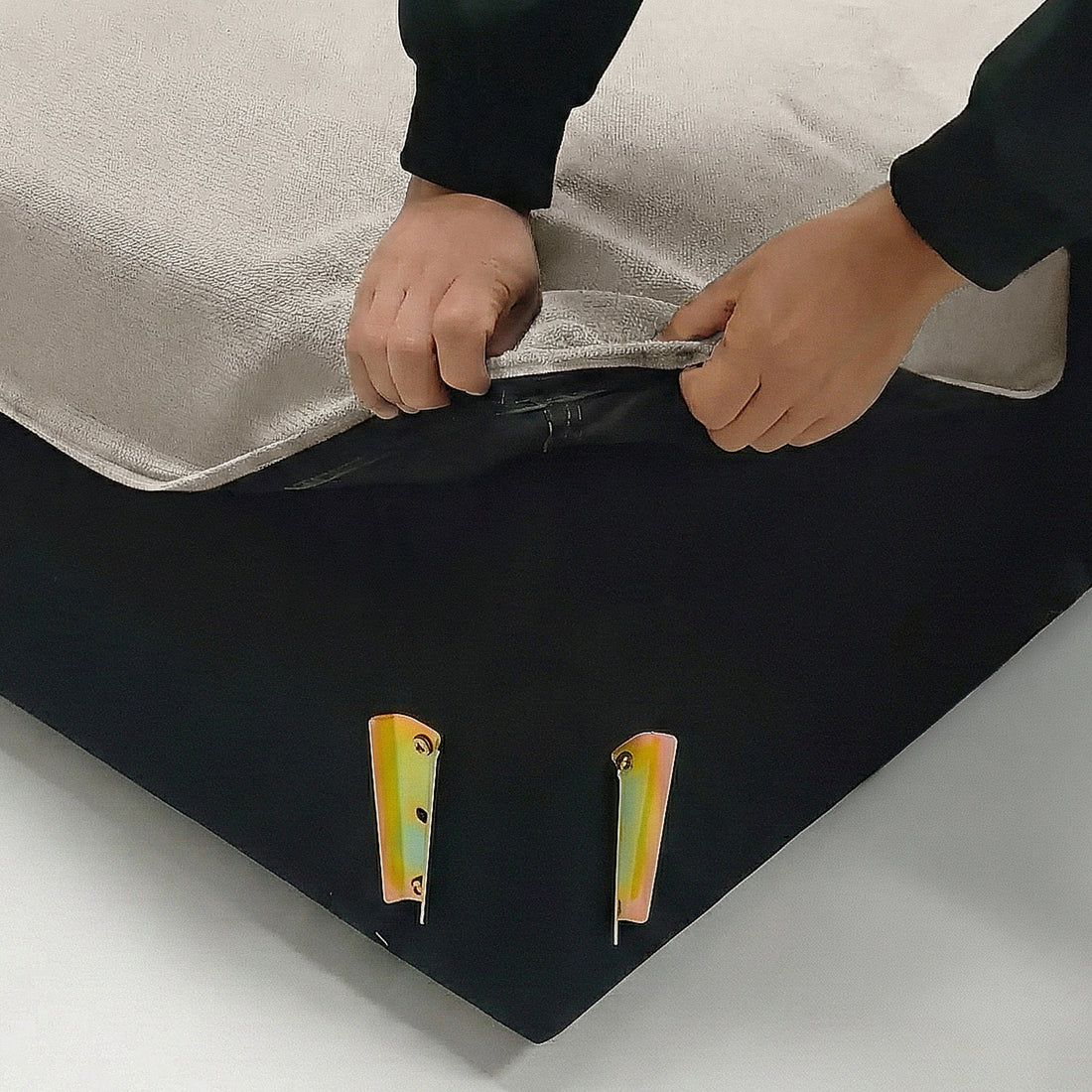 Hands unzipping fabric cover on corner of sofa