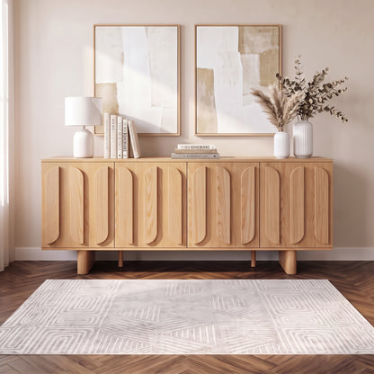 Wooden sideboard styled in a modern living space with books, lamp, vase, and wall art