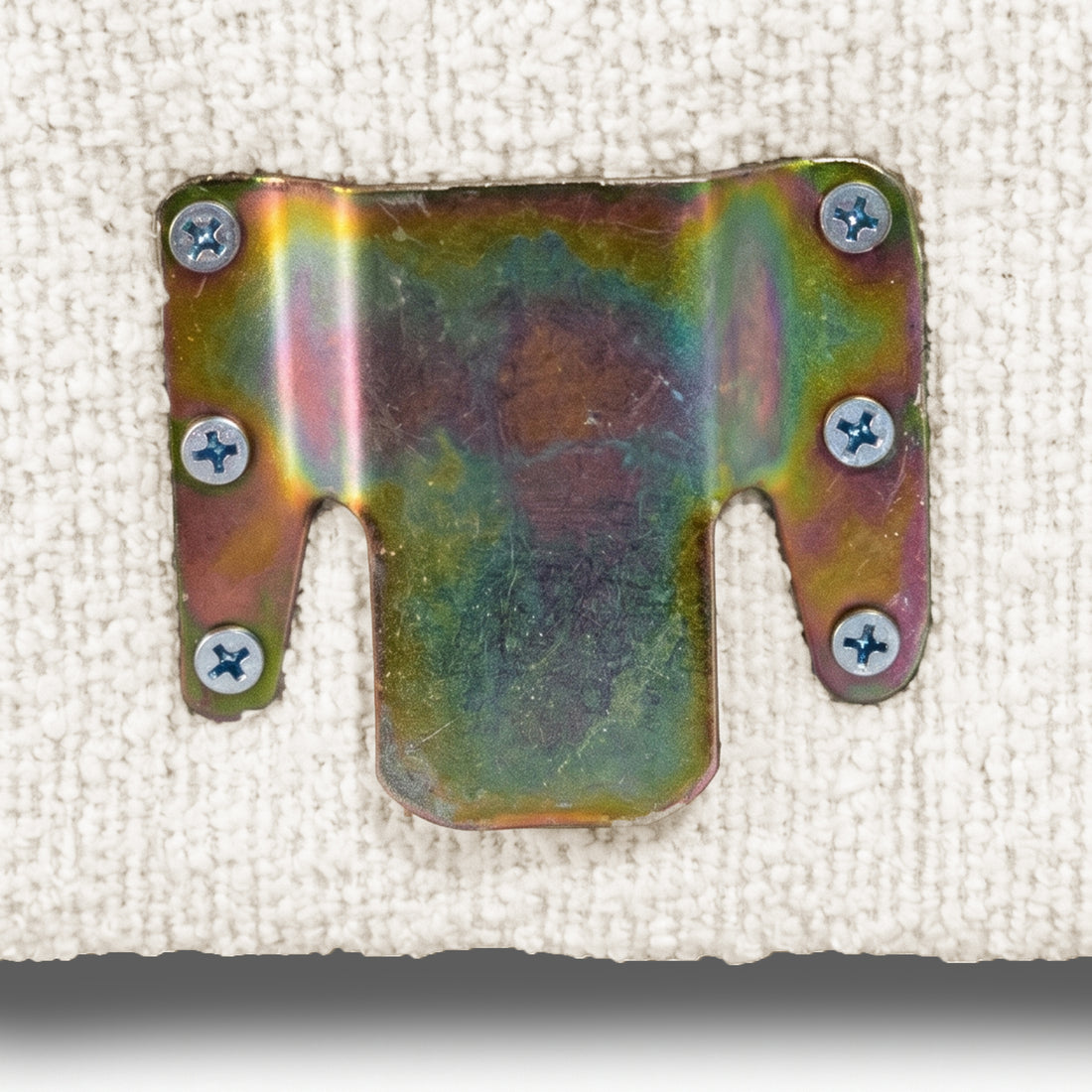 Detailed view of metal mounting bracket on boucle upholstery