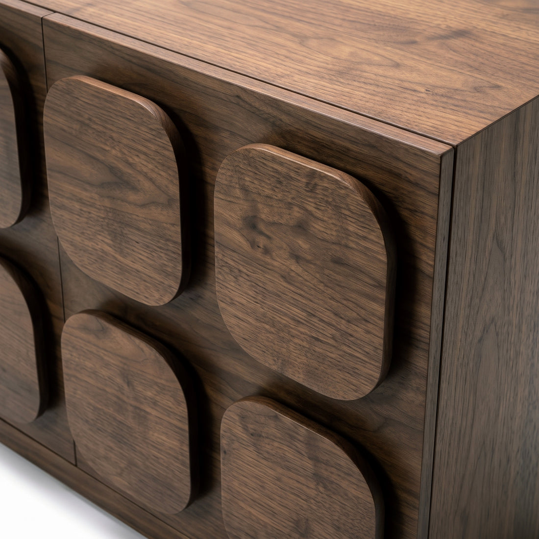 Close-up of the corner and side of a dark wood sideboard with textured panels