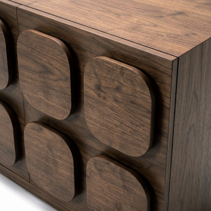 Close-up of the corner and side of a dark wood sideboard with textured panels