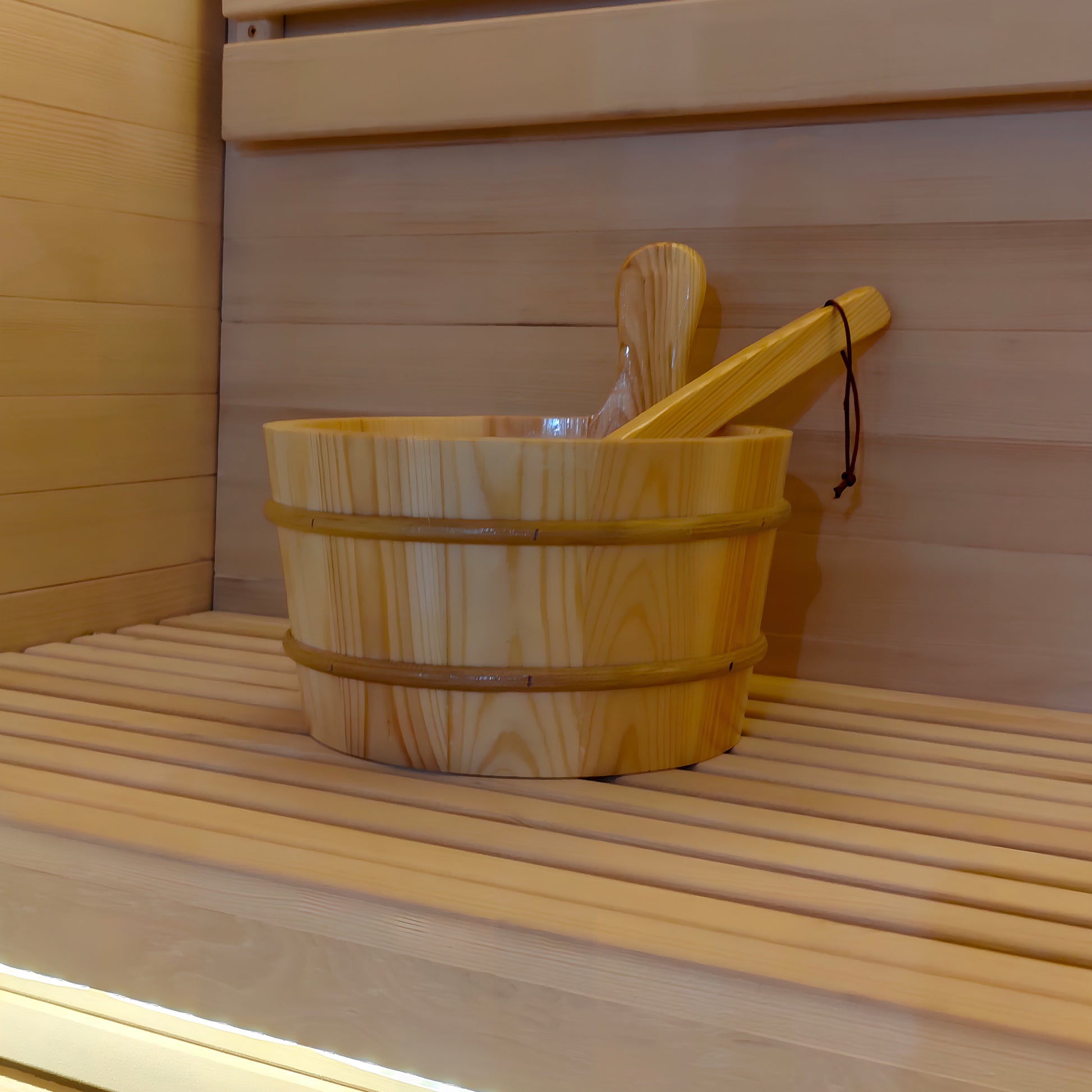 Wooden sauna bucket and ladle on a sauna bench