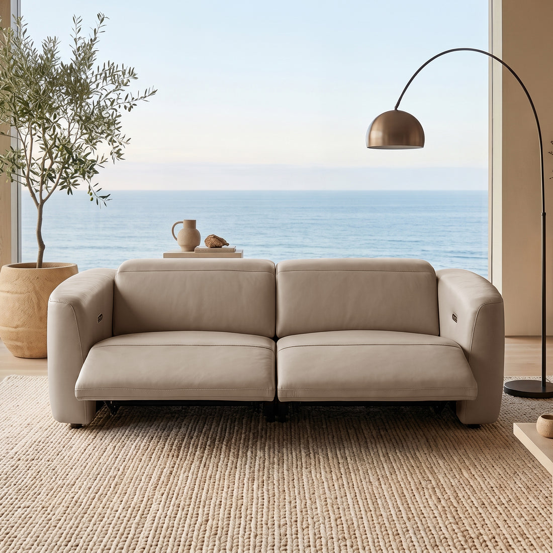 Beige sofa in a bright living room with ocean view through large windows