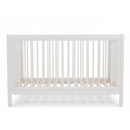 White baby crib with slatted sides on a white background