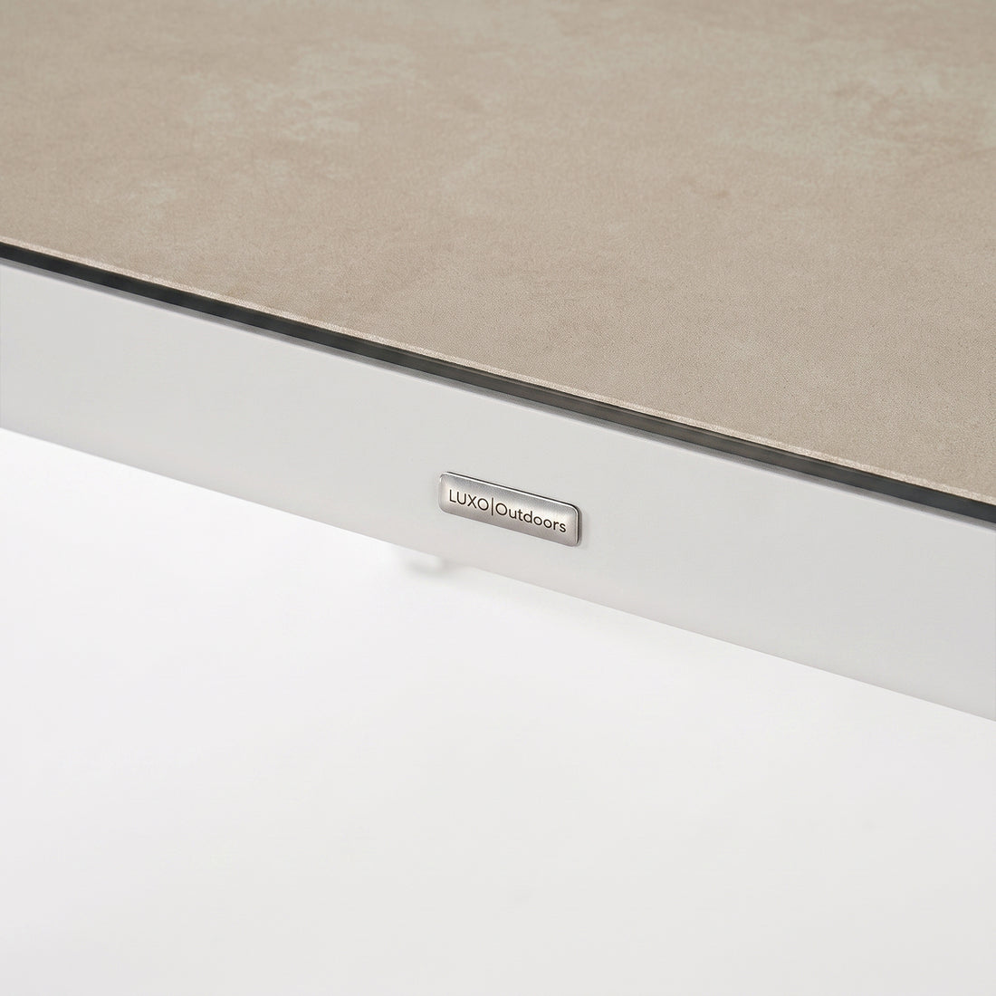 Close-up of the edge of a rectangular tabletop with a brand tag on a white background.