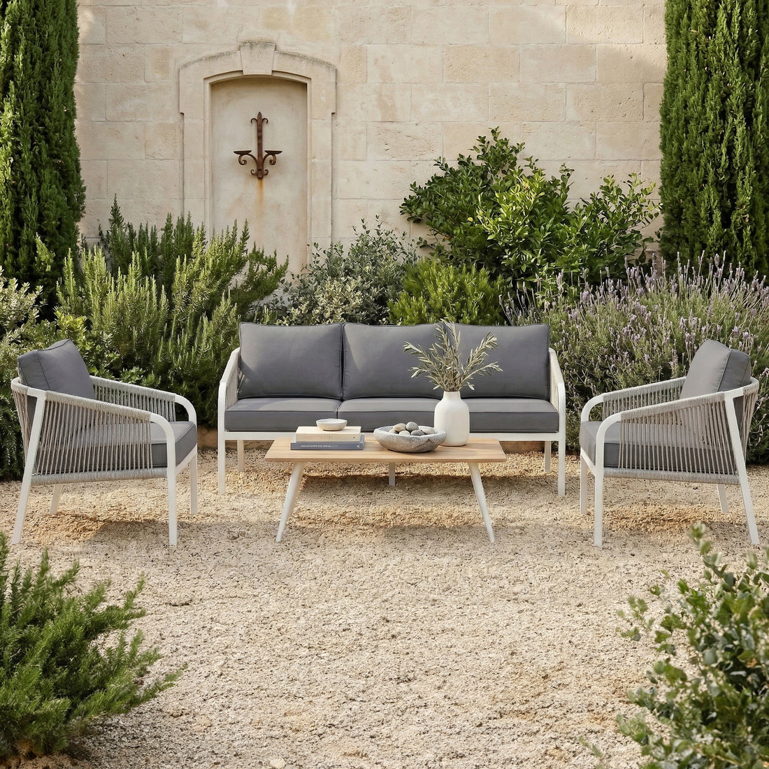 Vernon Outdoor Cushion Covers Set of 5 in Grey on patio armchairs and sofa, enhancing the seating with sleek, modern covers, surrounded by Mediterranean plants and a wooden coffee table with decorative items.