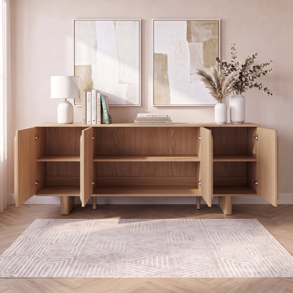 Wooden sideboard in a styled room with open cabinet doors, rug, lamp, and wall art