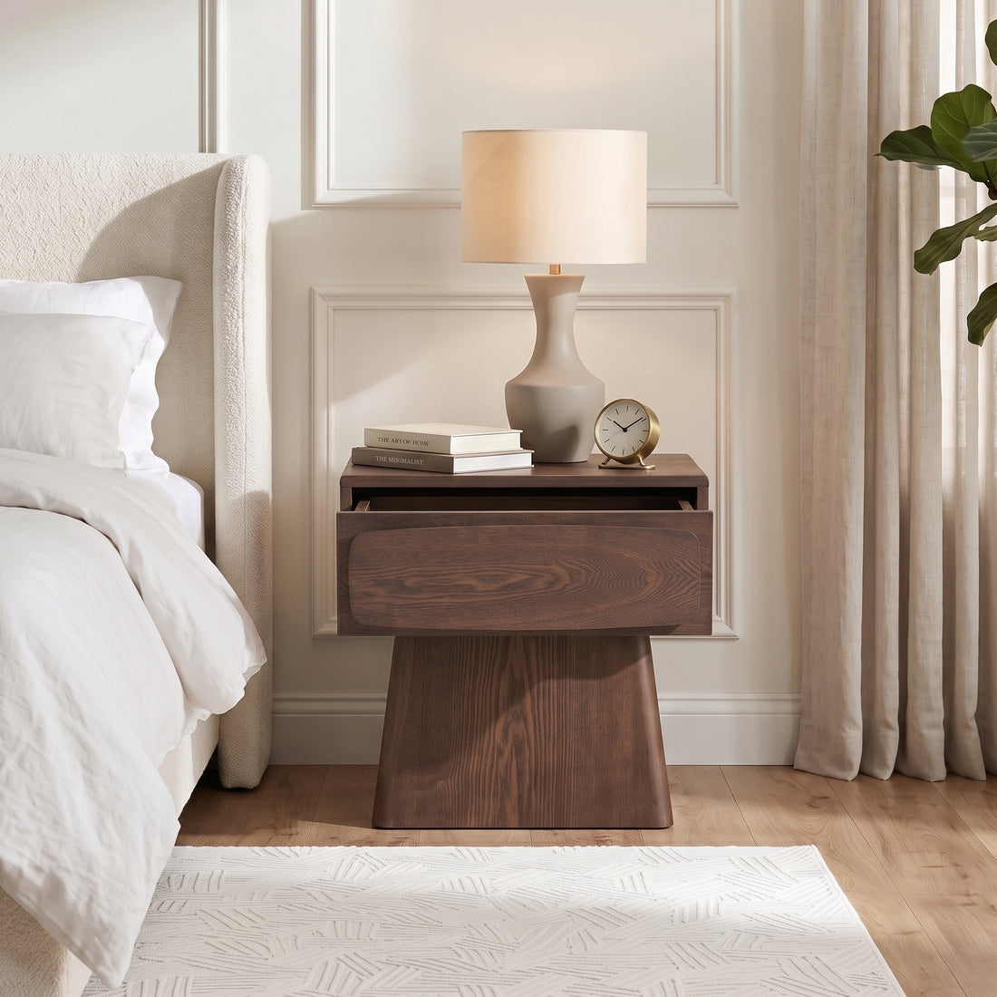 Dark wood nightstand styled in a bedroom next to a bed