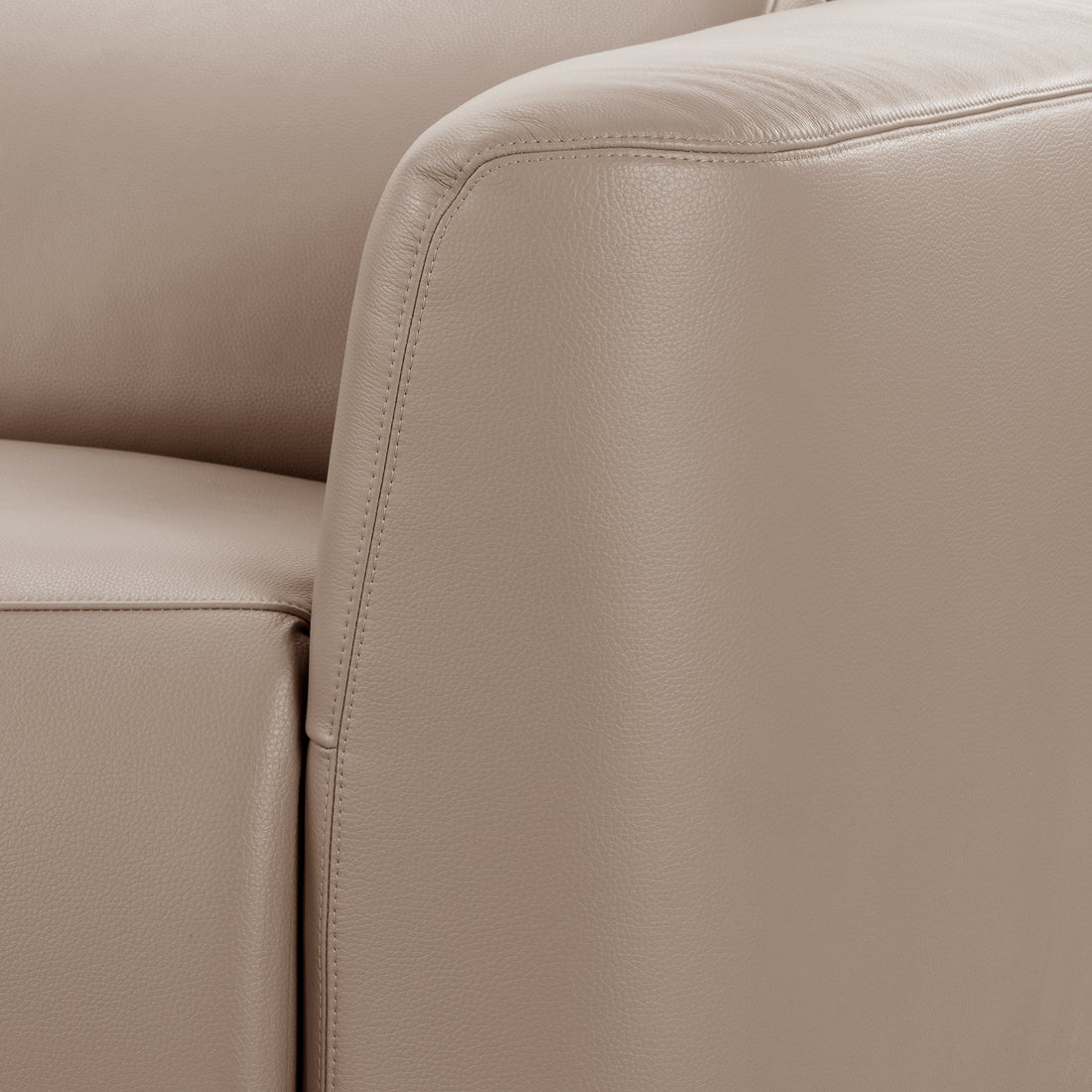 Close-up of beige leather sofa corner with stitching detail