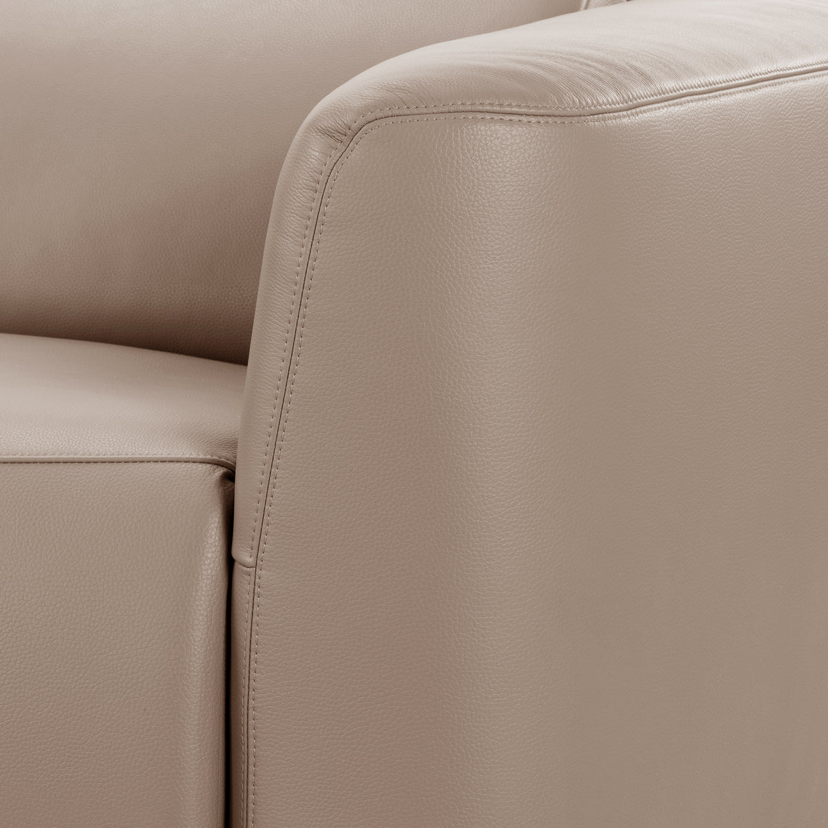 Close-up of beige leather sofa corner with stitching detail
