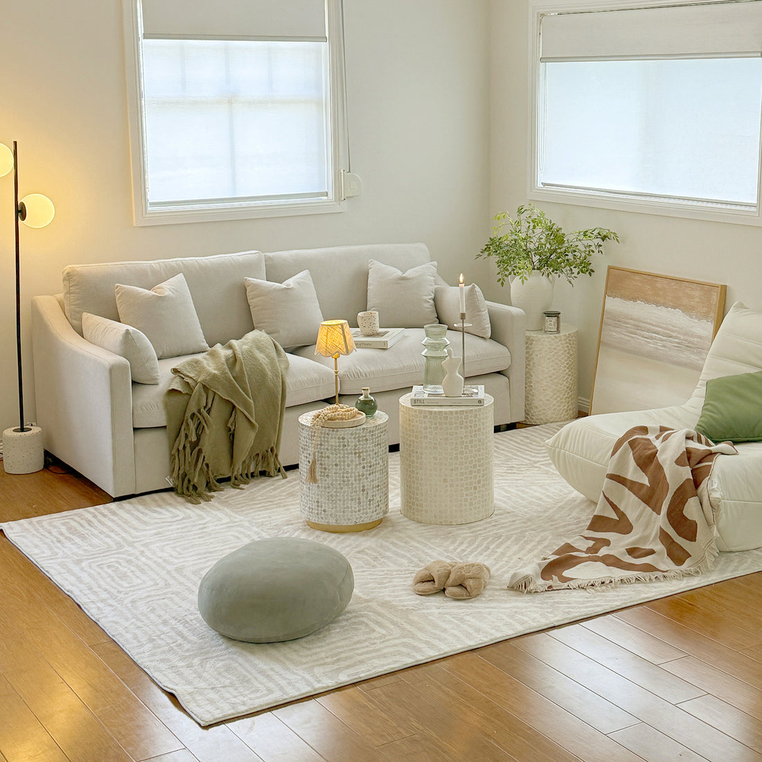 Stylish modern living room with white sofa, armchair, tables, and decor