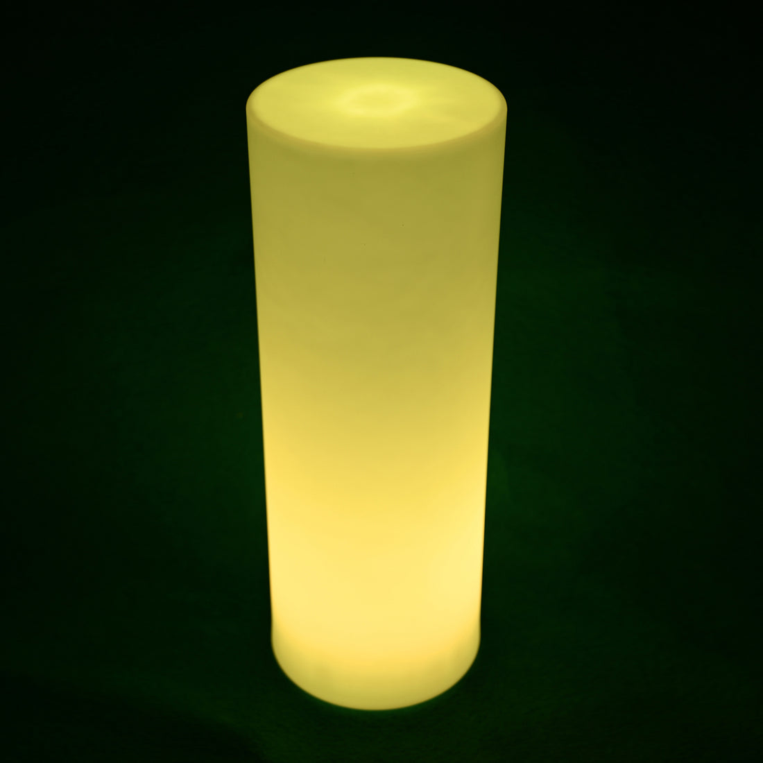16 Colour Outdoor LED Bollard Light in Multicolour glows softly, illuminating the dark backdrop. This cylindrical lamp provides vibrant outdoor lighting, enhancing pathways with easy control and cordless design.