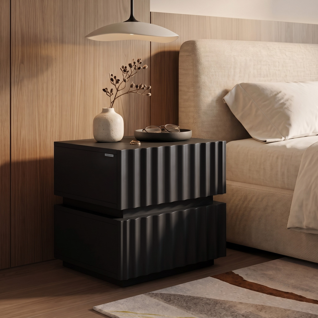 Modern black ribbed nightstand styled beside a bed in a bedroom setting.