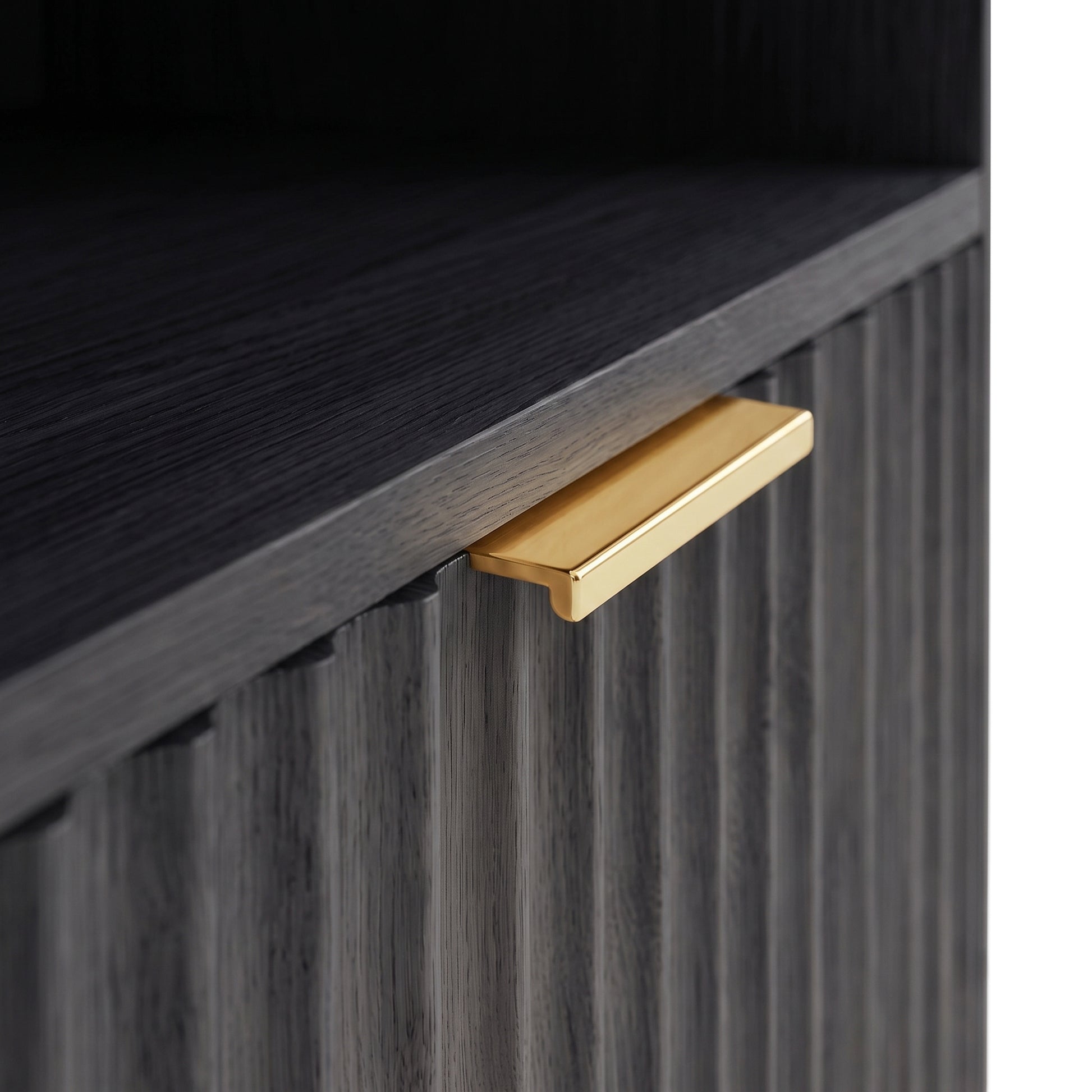 Close-up of textured black cabinet front with a gold handle