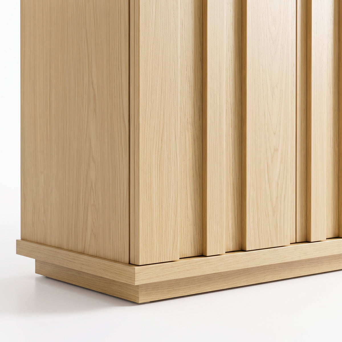 Close-up of the lower section of a light wood cabinet on a white background