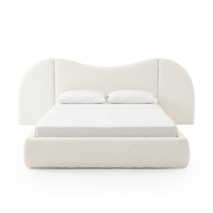 Contemporary upholstered bed with sculpted headboard on white background