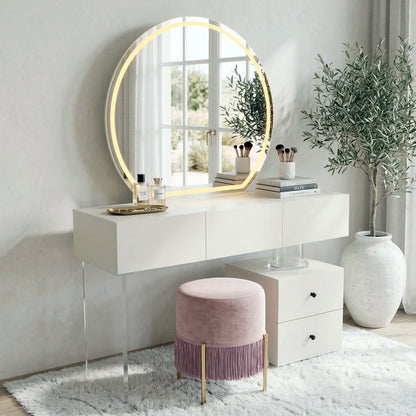 Styled vanity area with white table, round LED mirror, pink stool, and décor in a modern room