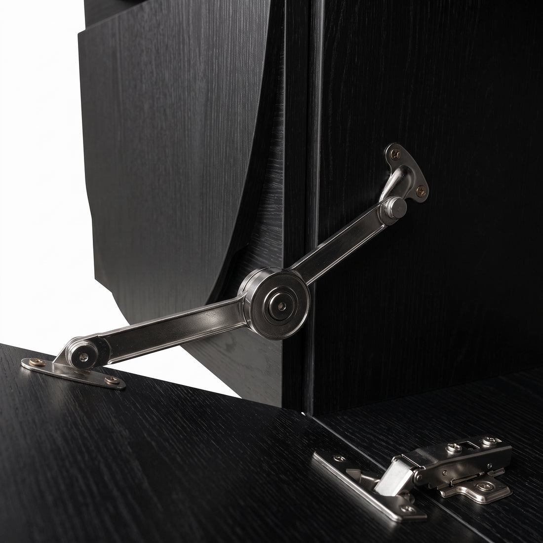 Close-up of a cabinet hinge and partially open door on a black furniture piece