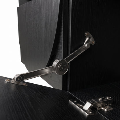 Close-up of a cabinet hinge and partially open door on a black furniture piece