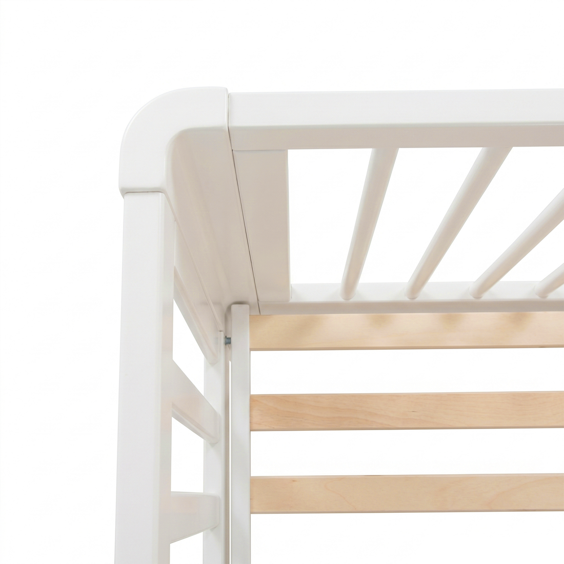 Close-up of top corner of white crib showing rounded corner and wooden slats