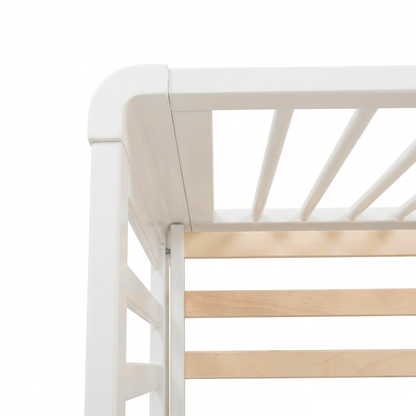 Close-up of top corner of white crib showing rounded corner and wooden slats