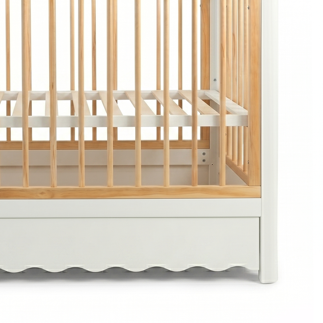 Close-up of lower side rails of wooden crib on white background