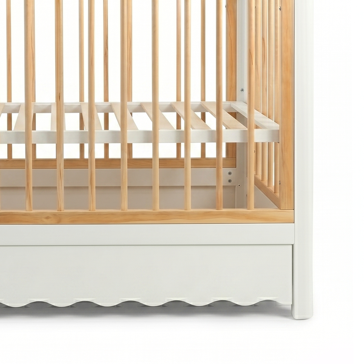 Close-up of lower side rails of wooden crib on white background