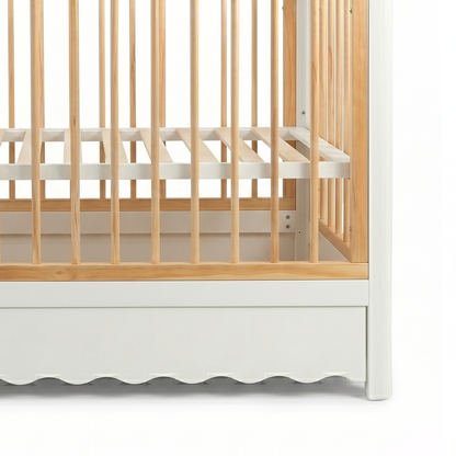 Close-up of lower side rails of wooden crib on white background