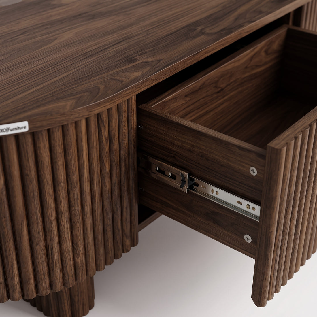 Close-up of an open wooden drawer on a ribbed dark wood cabinet