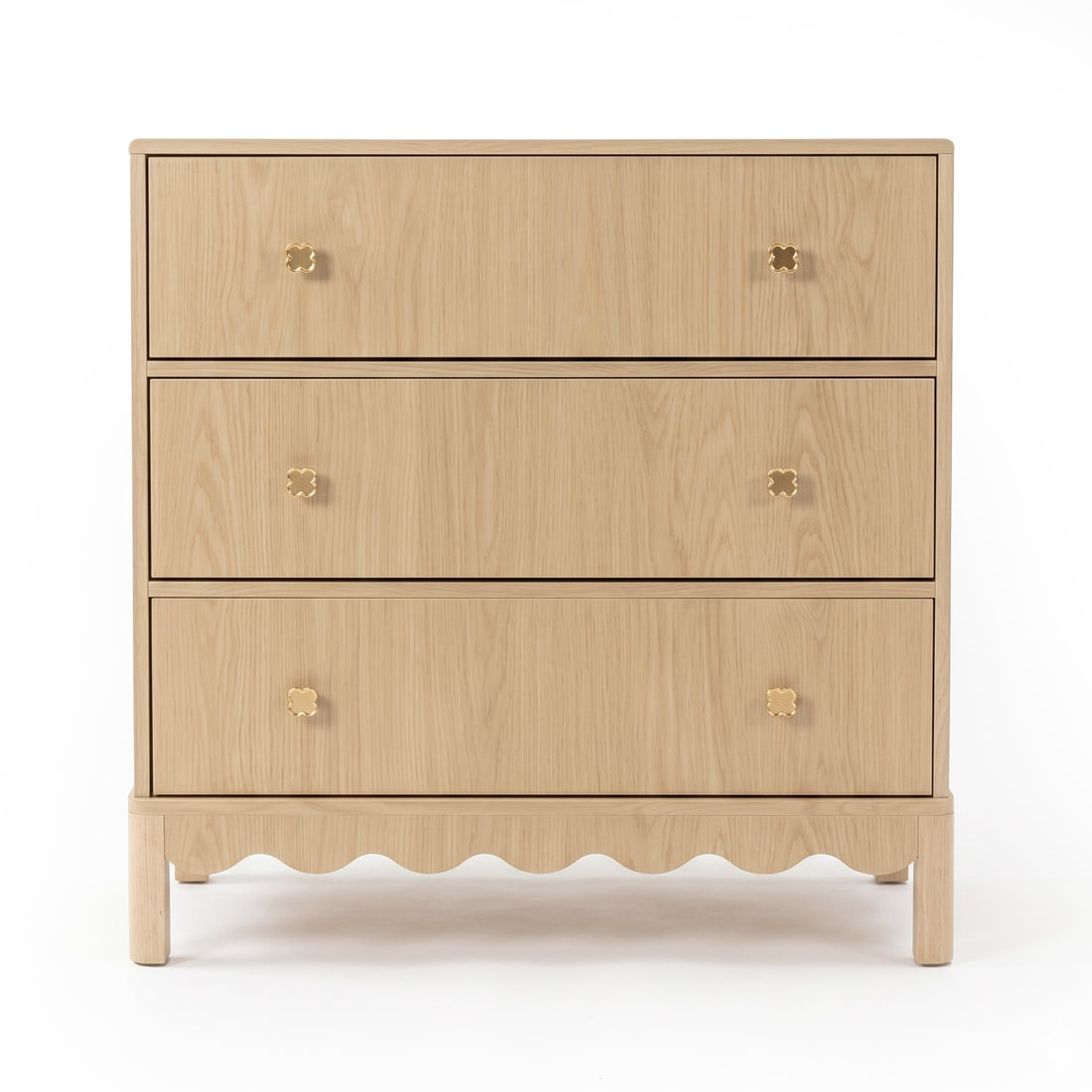 Three-drawer light wood dresser with gold flower knobs on white background