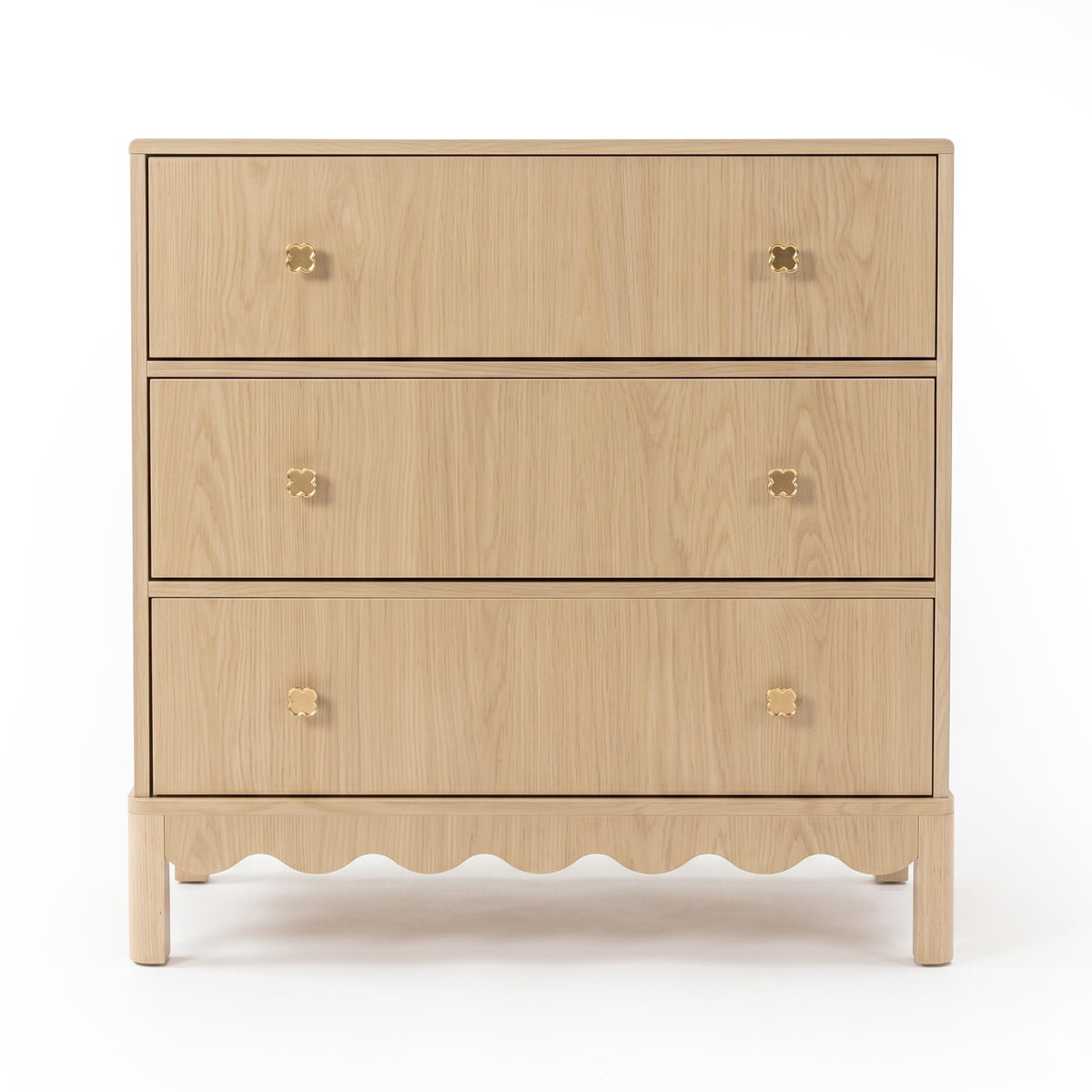 Three-drawer light wood dresser with gold flower knobs on white background