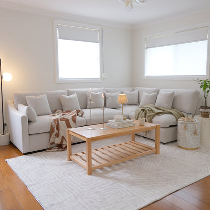 Light-colored sectional sofa in a bright, modern living room.
