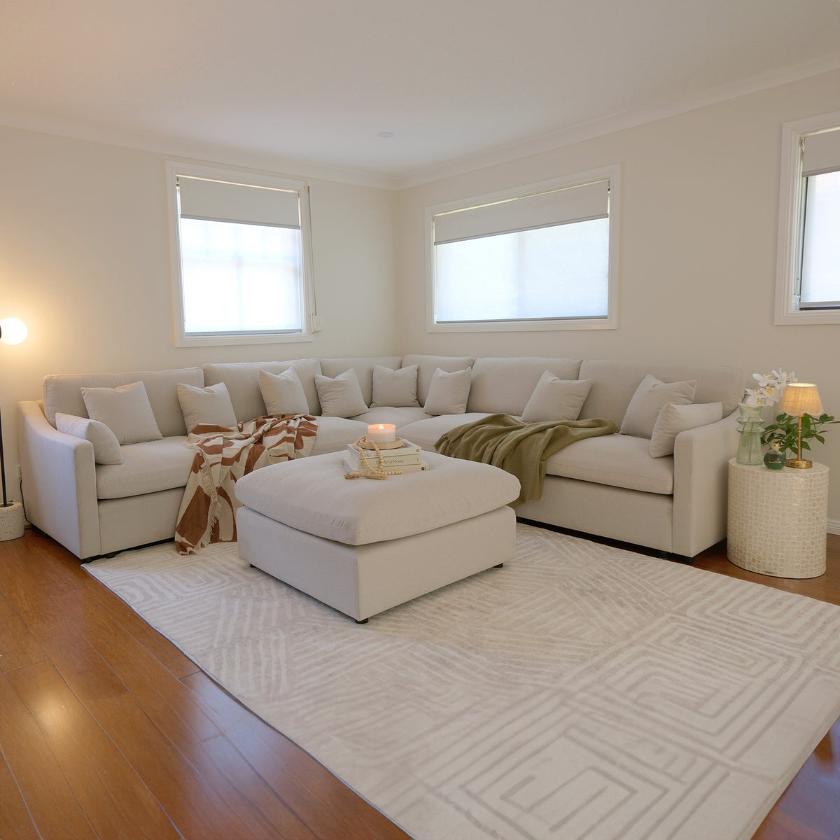 Light beige sectional sofa with ottoman styled in a modern living room