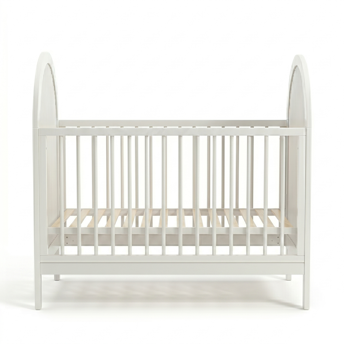 Front view of white baby crib with arched ends and vertical slats on white background