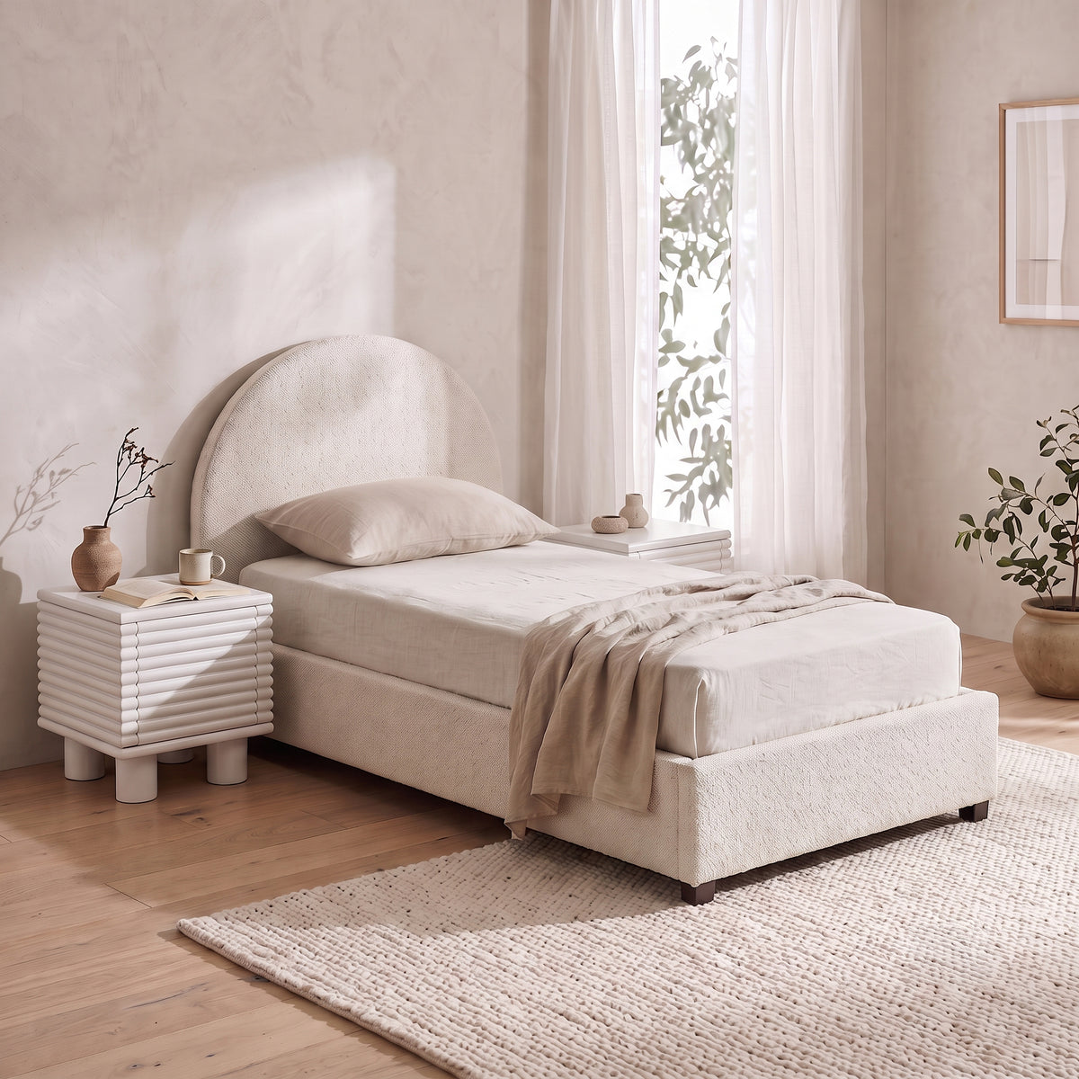 Cream bouclé single bed with an arched headboard and matching textured nightstand.