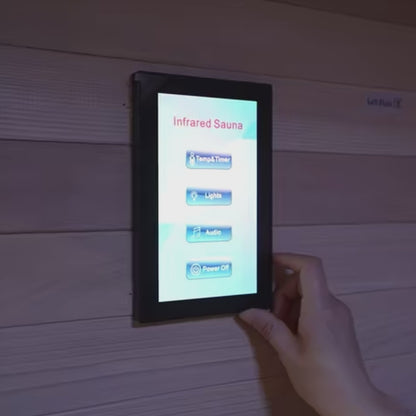Hand using infrared sauna touchscreen control panel